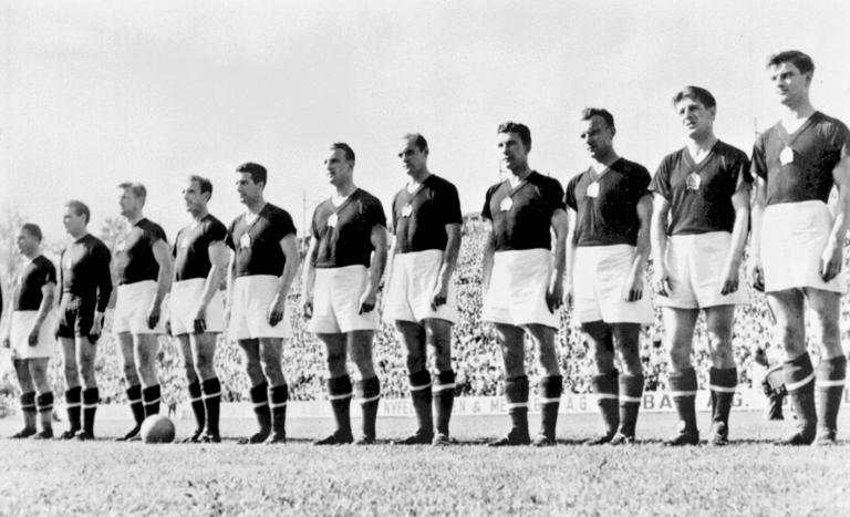 The Hungarian national soccer team is lined up during the national anthem before its World Cup first round soccer match against West Germany  20 June 1954 in Basel. (From L : Ferenc Puskas, Gyula Grosics, Gyula Lorant, Nandor Hidegkuti, Jozsef Boszik, Mihaly Lantos, Jeno Buzansky, Jozsef Zakarias, Jozsef Toth II, Zoltan Czibor, Sandor Kocsis). AFP PHOTO (Photo by STAFF / AFP) (Photo by STAFF/AFP via Getty Images)