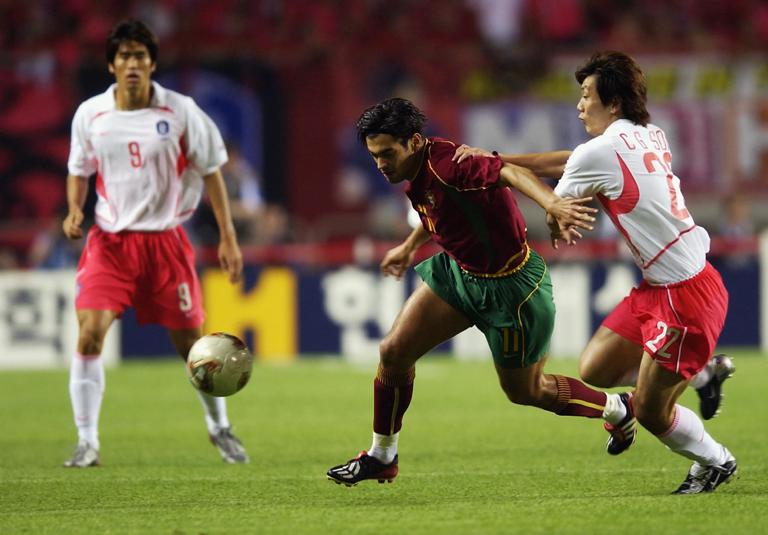 INCHEON - JUNE 14:  Chong Gug Song of South Korea holds back Sergio Conceicao of Portugal during the FIFA World Cup Finals 2002 Group D match played at the Incheon Munhak Stadium, in Incheon, South Korea on June 14, 2002. South Korea won the match 1-0. DIGITAL IMAGE. (Photo by Clive Brunskill/Getty Images)